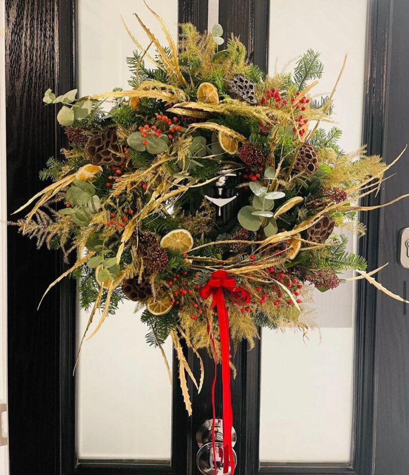 Golden Christmas Wreath. Sprinkled with a gold fern and velvet bow. Order online for your next day flower delivery. Bishops Stortford