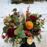 Home for Christmas. Traditional circular table decoration with seasonal foliage. Order online for your next day flower delivery. Bishops Stortford