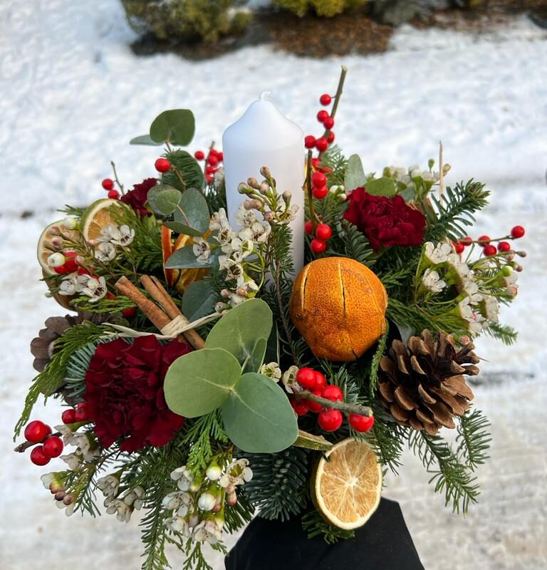 Home for Christmas. Traditional circular table decoration with seasonal foliage. Order online for your next day flower delivery. Bishops Stortford