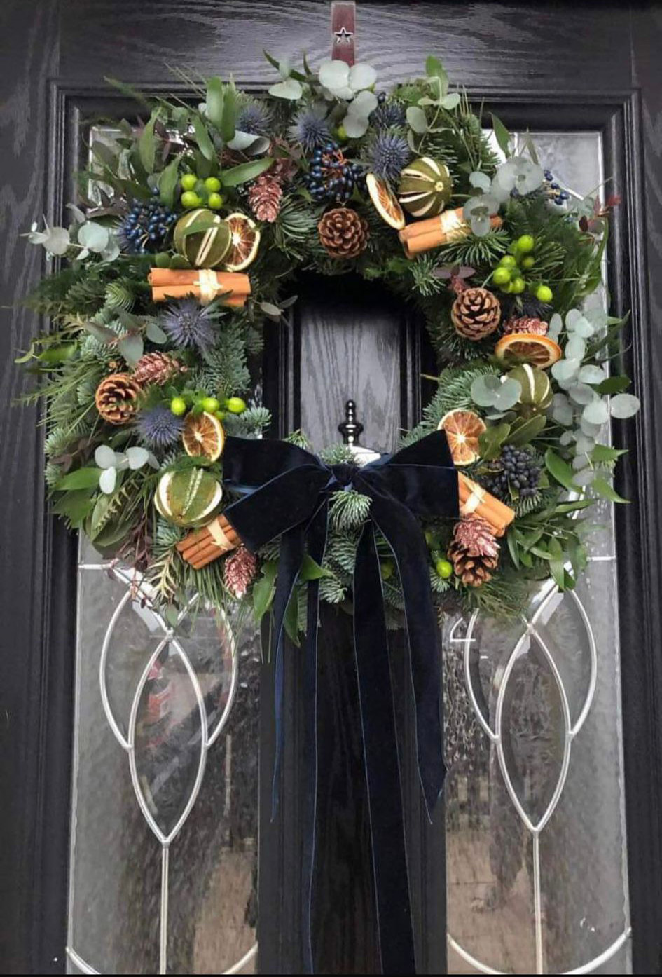 Blue Christmas Wreath. The deep blue velvet bow adds a touch of elegance. Order online for your next day flower delivery. Bishops Stortford
